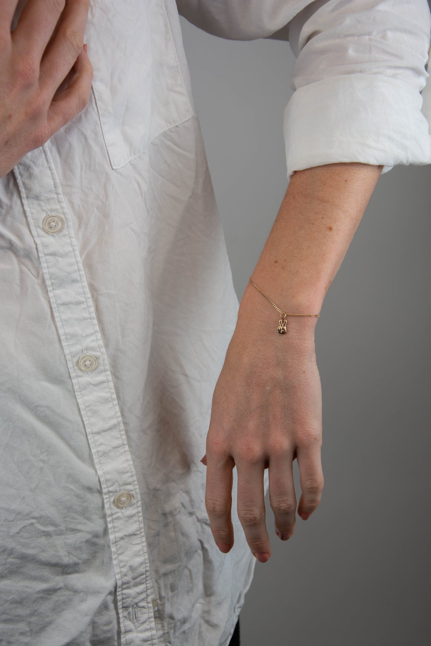 Solid 14k gold curbed chain peace sign charm bracelet handmade in Asheville, NC.
