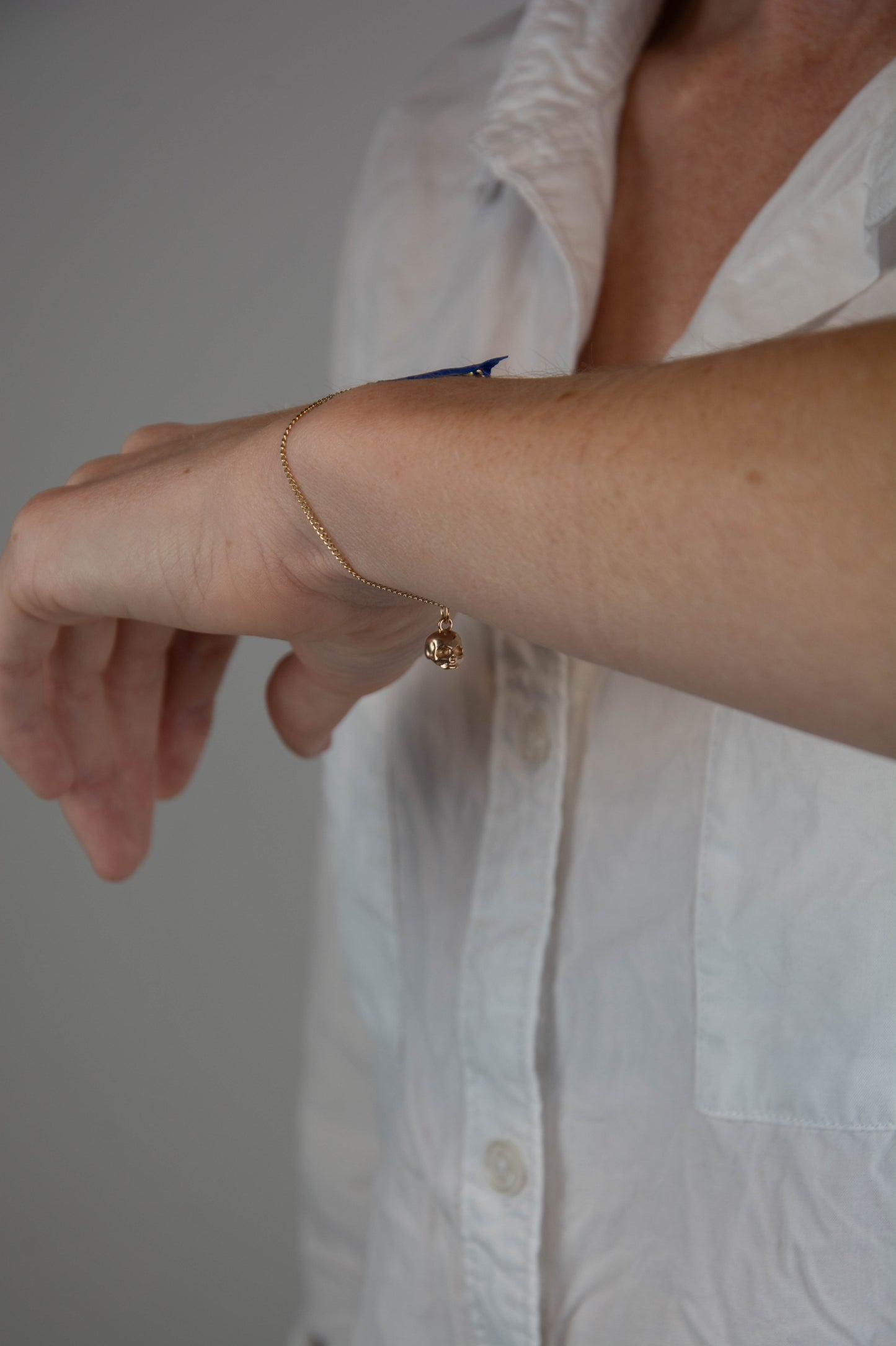 Solid 14k gold curbed chain skull charm bracelet handmade in Asheville, NC.